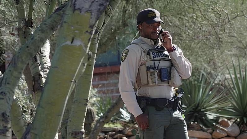 A Pima County sheriffs official stays outside Nancy Guthrie’s home in Tucson, Arizona, on Saturday.