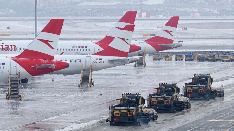 Snowplows drive next to parked Austrian Airlines planes on the tarmac of Vienna International Airport (VIE), in Schwechat, Austria, January 13, 2026. REUTERS/Leonhard Foeger/File Photo