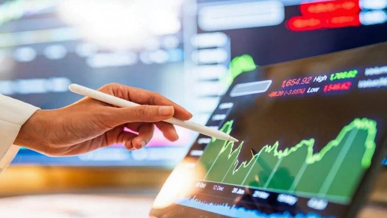 Executivo analisa gráficos em uma tela.