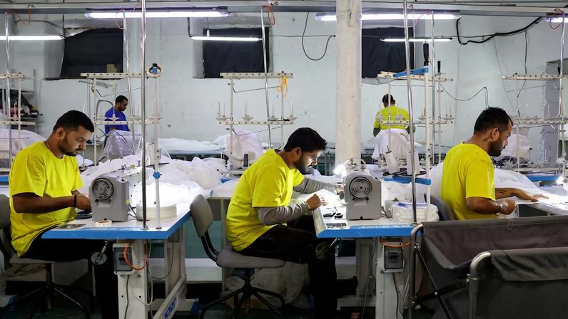 Migrant workers from India sew tulle fabric at a textile factory in Balashikha