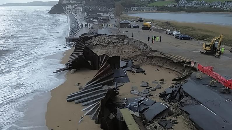 The A379 Slapton Line between Torcross and Slapton has washed away. The image shows a gaping hole in the street.