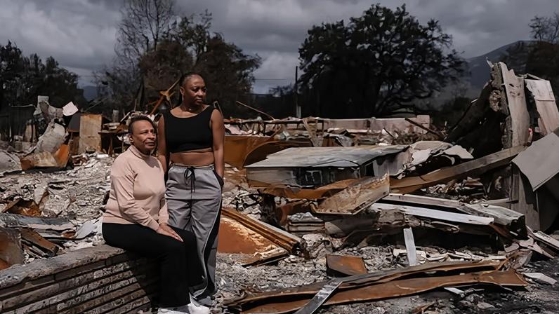 Barbara Shay, owner of Little Red Hen Coffee Shop, and her daughter, Annisa Faquir, pause for a portrait near ruins of their business.