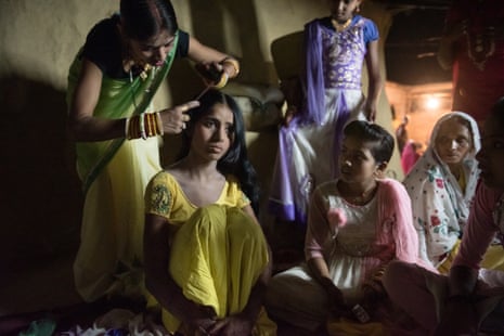 Surrounded by friends and relatives, Arti, 14, has her hair and makeup done as she prepares for her wedding ceremony.