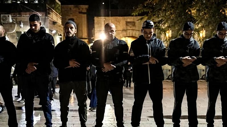 Palestinian Muslim worshippers banned from entering the al-Aqsa mosque compound in the Old City of Jerusalem pray outside at the end of the first day of Ramadan.