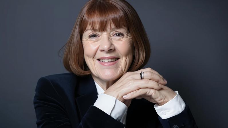 Gisèle Pelicot smiling, posing for photo in black velvet jacket