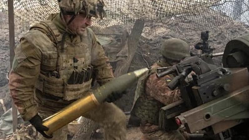 A Ukrainian soldier loads a British-made L119 howitzer at an undisclosed location in Ukraine.