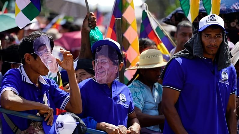 Men wearing masks depicting the former Bolivian president Evo Morales take part in the celebrations marking the Day of the Plurinational State, in Shinaota, Bolivia, on 23 January.