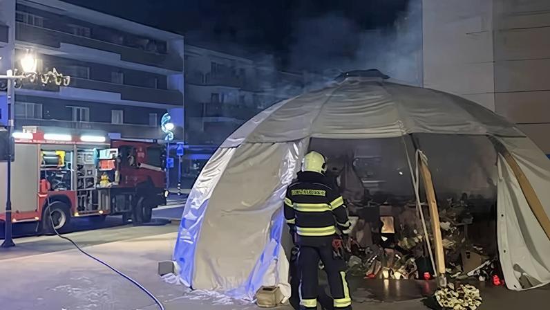 Un bombero inspecciona el domingo el memorial improvisado en homenaje a las víctimas del incendio del bar Le Constellation, en Crans-Montana (Suiza).