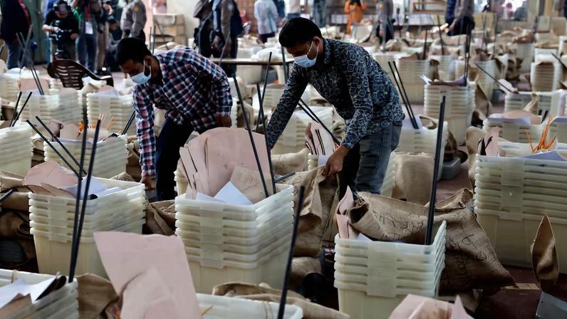 Officials give a final check before dispatching the ballot boxes to voting centres, a day ahead of the national election in Dhaka