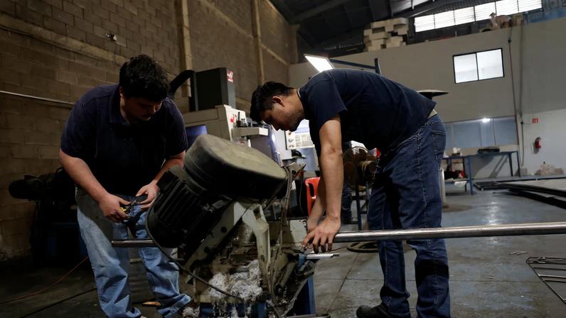 Workers cut a steel bar at a metal-mechanical parts factory in Apodaca, Mexico, March 11, 2025. REUTERS/Daniel Becerril/File Photo