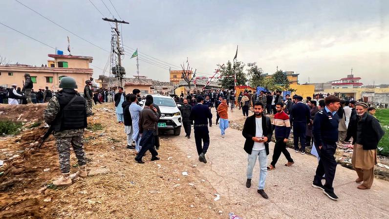 Pakistani paramilitary federal forces stand guard next to a crowd of people gathered near the site of a deadly explosion at a Shi'ite Muslim mosque in Islamabad, Pakistan, February 6, 2026. Picture taken with a phone.