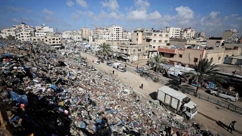 Palestinians walk near a landfill, in Gaza City, February 11, 2026. REUTERS/Dawoud Abu Alkas