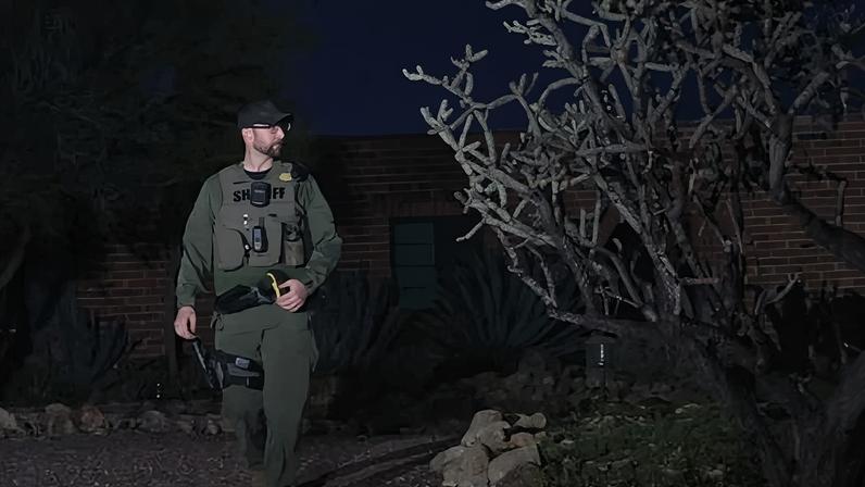 A sheriff officer walks on a property