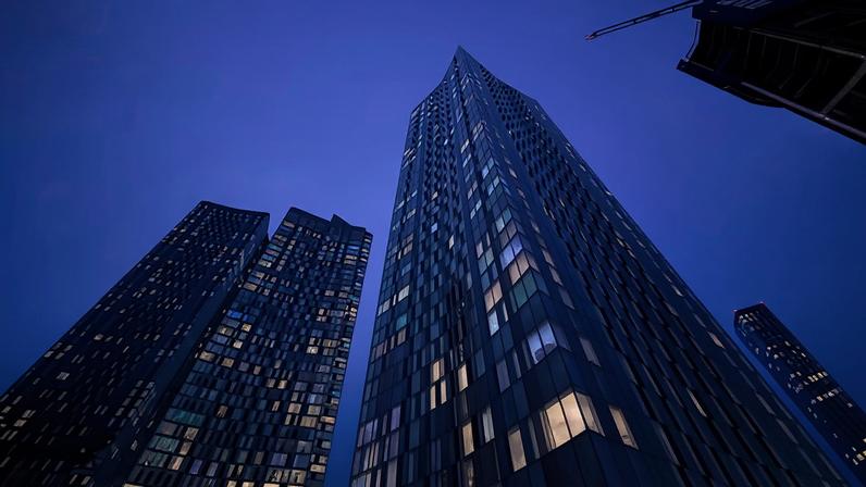 Low angle of a cluster of residential skyscrapers at night with lights coming from the windows
