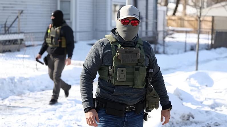 Federal agents look on after they detained a protester in Minneapolis, Minnesota, on 03 February 2026.