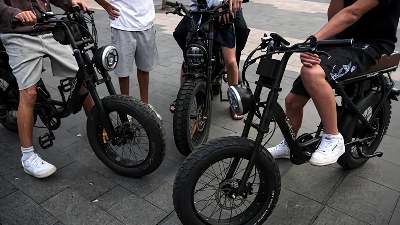 Schoolboys cruise on e-bikes at Manly Beach on Sydney’s Northern Beaches.