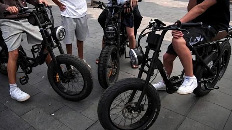 Schoolboys cruise on ebikes at Manly Beach on Sydney’s Northern Beaches