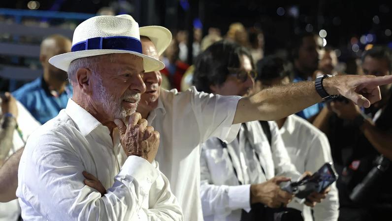 O presidente Luiz Inácio Lula da Silva observa o desfile da Acadêmicos de Niterói junto ao prefeito do Rio de Janeiro, Eduardo Paes. (Foto: Antonio Lacerda / EFE)