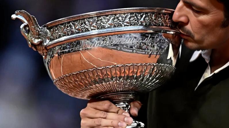 O espanhol Carlos Alcaraz beija o troféu de Roland Garros (Foto: JULIEN DE ROSA / AFP)