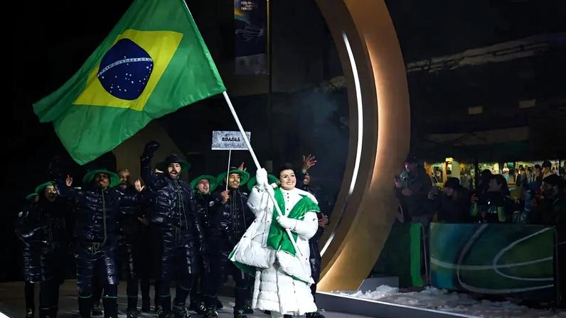A porta-bandeira do Brasil, Nicole Rocha Silveira (D), desfila com a delegação na cerimônia de abertura dos Jogos Olímpicos de Inverno Milano Cortina 2026, em 6 de fevereiro de 2026. (Foto: Franck Fife/AFP)