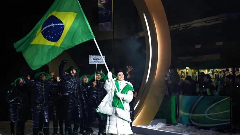 A porta-bandeira do Brasil, Nicole Rocha Silveira (D), desfila com a delegação na cerimônia de abertura dos Jogos Olímpicos de Inverno Milano Cortina 2026, em 6 de fevereiro de 2026. (Foto: Franck Fife/AFP)