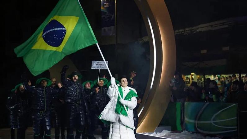 A porta-bandeira do Brasil, Nicole Rocha Silveira (D), desfila com a delegação na cerimônia de abertura dos Jogos Olímpicos de Inverno Milano Cortina 2026, em 6 de fevereiro de 2026. (Foto: Franck Fife/AFP)