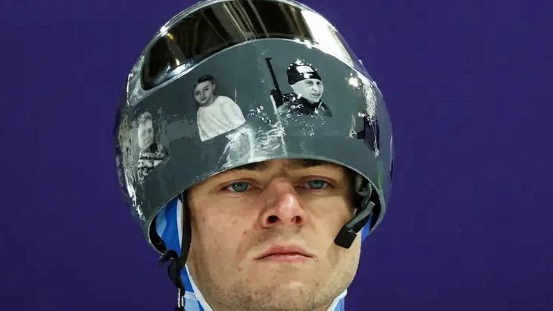o ucraniano Vladyslav Heraskevych usa capacete com imagens de atletas vítimas da guerra com a Rússia durante treino de skeleton em Cortina. Ele foi desclassificado dos Jogos por se recusar a retirar o item. (Foto: Franck Fife/AFP)