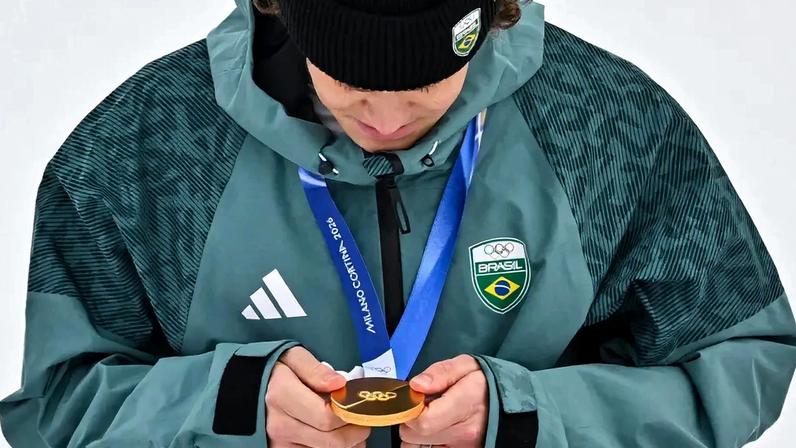 Lucas Pinheiro Braathen observa a medalha de ouro no pódio do slalom gigante masculino em 2026. (Foto: Fabrice Coffrini/AFP)