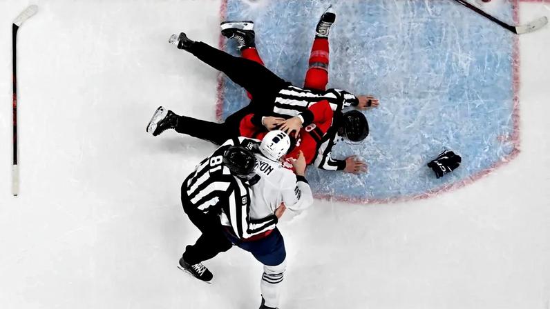 Os bandeirinhas Daniel Hynek e Ryan Daisy tentam separar o francês Pierre Crinon (nº 7) e o canadense Thomas Wilson (nº 43, de vermelho) durante uma confusão na partida de hóquei no gelo masculino do Grupo A da fase preliminar entre Canadá e França, na Arena de Hóquei no Gelo Milano Santagiulia, durante as Olimpíadas de Inverno de Milão-Cortina 2026 (Foto: Alexander Nemenov / AFP)