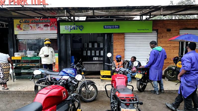 Riders swap batteries at an electric Spiro motorcycle charging station in Nairobi, Kenya, Tuesday, Feb. 24, 2026. (AP Photo/Henry Naminde)