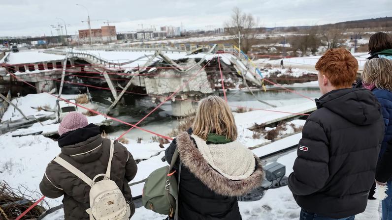 People attend a memorial event to mark the fourth anniversary of the full-scale Russian invasion, amid Russia's attack on Ukraine, at Romanivskyi Bridge, which was destroyed at the beginning of the war and which was the main way for evacuations of civilians from the front line area around the Ukrainian capital, in Irpin, outside of Kyiv, Ukraine February 24, 2026. REUTERS/Gleb Garanich