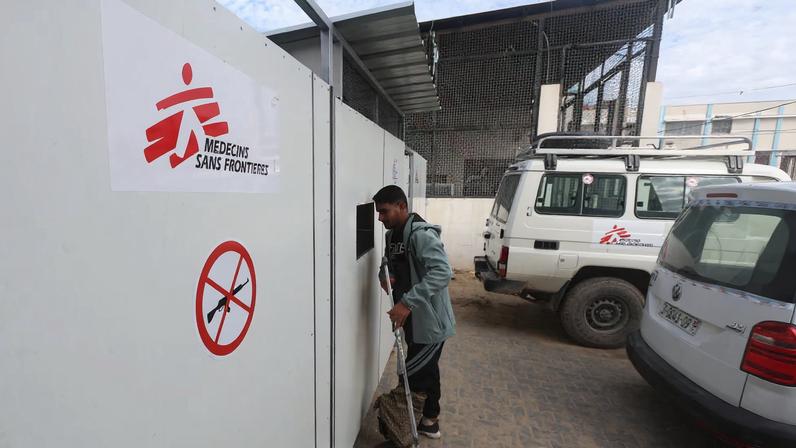 A Palestinian war-wounded man waits at the entrance, hoping to receive medical treatment, at a clinic run by medical charity Medecins Sans Frontieres (MSF), amid shortages of medical supplies, in Khan Younis, southern Gaza Strip, December 31, 2025.