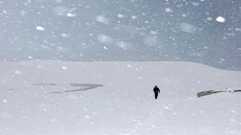 A man walks through the snowfall amid piled-up snow at the Tottori Sand Dunes in Tottori