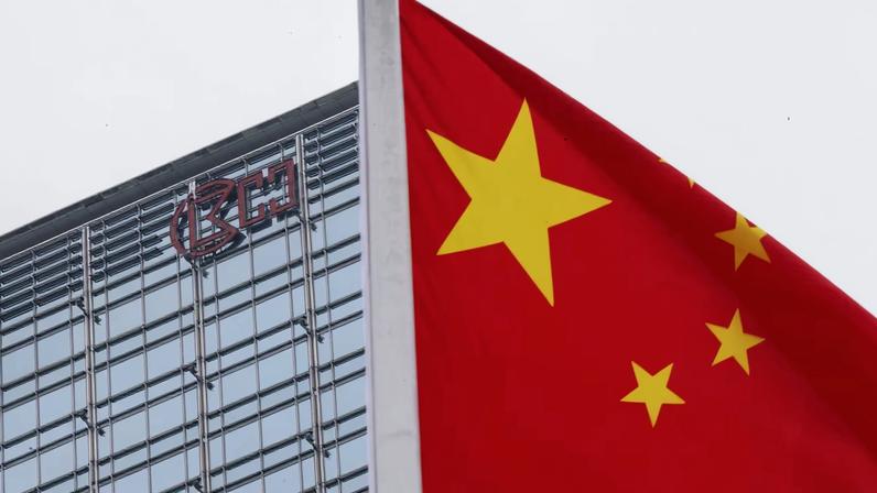 A Chinese national flag flutters in the wind with the Cheung Kong Center building and CK Hutchison logo in the background in Hong Kong