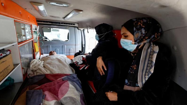 Palestinian patients, accompanied by relatives, make their way back to their homes in Khan Younis