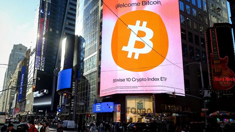 Símbolo do bitcoin na Times Square: para o investidor de varejo, o respaldo institucional trouxe até agora mais dor do que proteção.