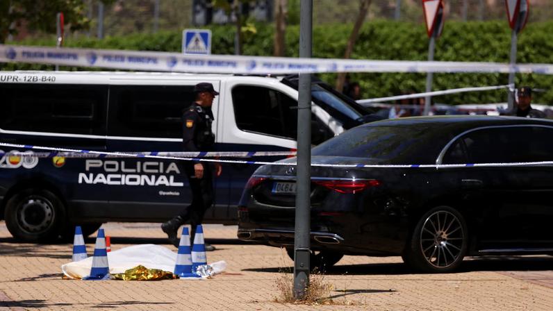 A Police officer walks near the body of former Ukrainian politician Andriy Portnov, at the spot where, according to the Spain's Interior Ministry, he was shot and killed by unidentified gunmen, outside a school, in Madrid, Spain May 21, 2025.