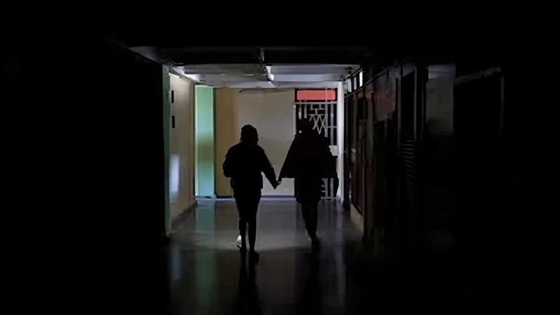 Personas iluminan un pasillo con un teléfono este miércoles, en La Habana (Cuba).