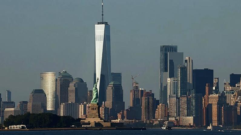 Lower Manhattan e o One World Trade Center, ao fundo da Estátua da Liberdade, na cidade de Nova York,