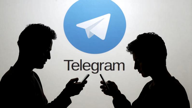 Two men pose with smartphones in front of a screen showing the Telegram logo in this picture illustration taken in Zenica, Bosnia and Herzegovina November 18, 2015. REUTERS/Dado Ruvic/File Photo