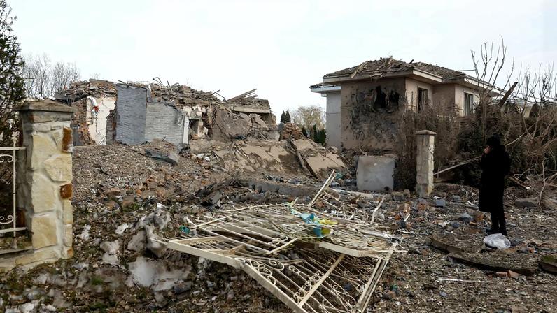 A woman looks at houses heavily damaged by a Russian missile strike, amid Russia's attack on Ukraine, in Kyiv region, Ukraine February 22, 2026. REUTERS/Valentyn Ogirenko