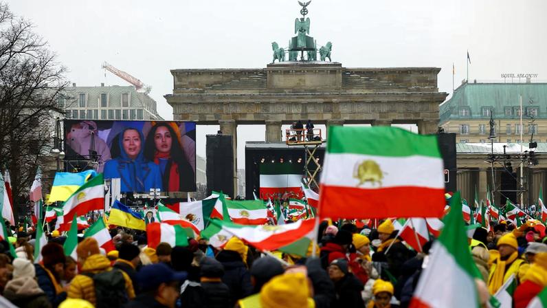 Demonstrators watch on screen Iranian opposition leader Maryam Rajavi speaking on stage, during a protest organized by supporters of the Iranian opposition group, the National Council of Resistance of Iran, to demand an immediate stop to the violence against protesters in Iran and an end to detentions and repression, in Berlin, Germany, February 7, 2026.
