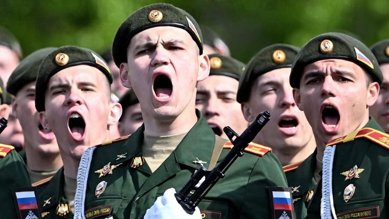 Men in military uniforms are shown close-up and appear to be shouting.