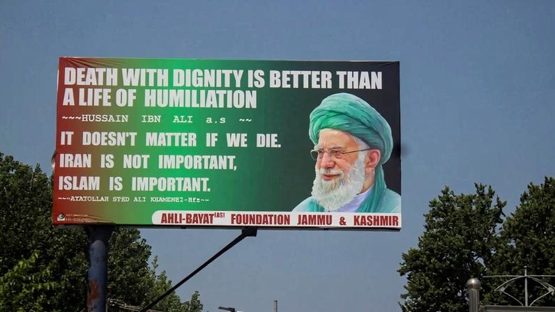 A large poster of Ayatollah Ali Khamenei displays words: “Death with dignity is better than a life of humiliation” during a Muharram procession in Srinagar, Jammu and Kashmir, India, on July 4, 2025.