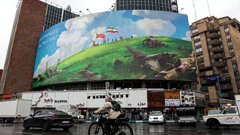 A cyclist rides past an anti-U.S. billboard displayed on a building in Tehran's Valiasr Square on Feb. 4.