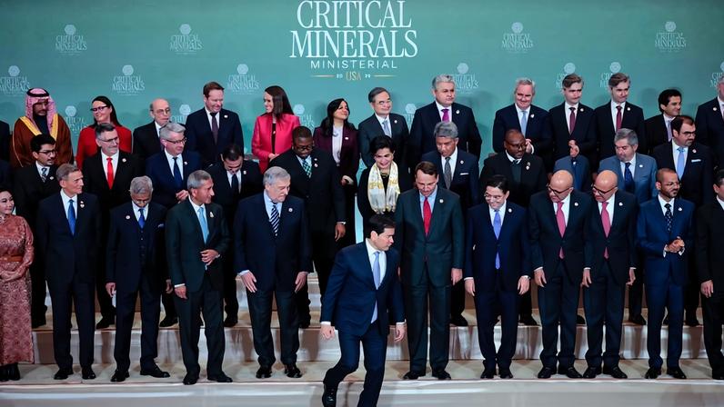 Multiple officials dressed in business attire pose for a photo.