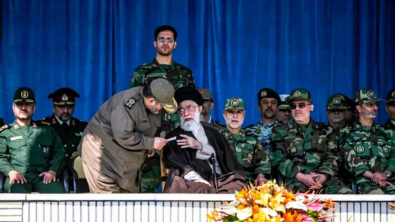 A senior Iranian military official approaches Iran’s Supreme Leader Ayatollah Ali Khamenei during a graduation ceremony at Shahid Sattari Air Force Academy in Tehran, Iran, on October 24, 2007.