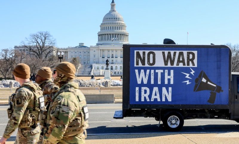 A group of U.S. National Guardsmen walk past a truck displaying the message "No War With Iran" in front of the U.S. Capitol in Washington on Feb. 24.
