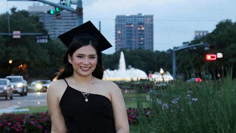 Babson College student Any Lucia Lopez Belloza poses wearing a mortarboard after graduating from high school in Boston