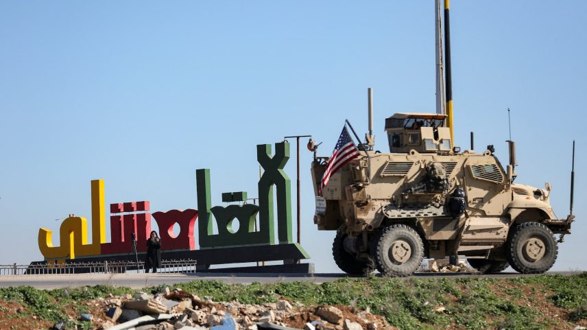 An armoured U.S. military vehicle with a U.S. flag on it moves towards the Iraqi Kurdistan region, withdrawing from Qasrak military base in northeastern Syria, in Qamishli, Syria, February 23, 2026.